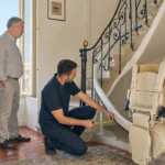Installateur évaluant un escalier étroit dans un logement marseillais avant la pose d'un monte-escalier.